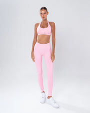 דוגמנית לובשת טייץ ורוד מחטב לנשים עם כיווץ נסתר וגזרת V – AURA PINK של Inner Dragon