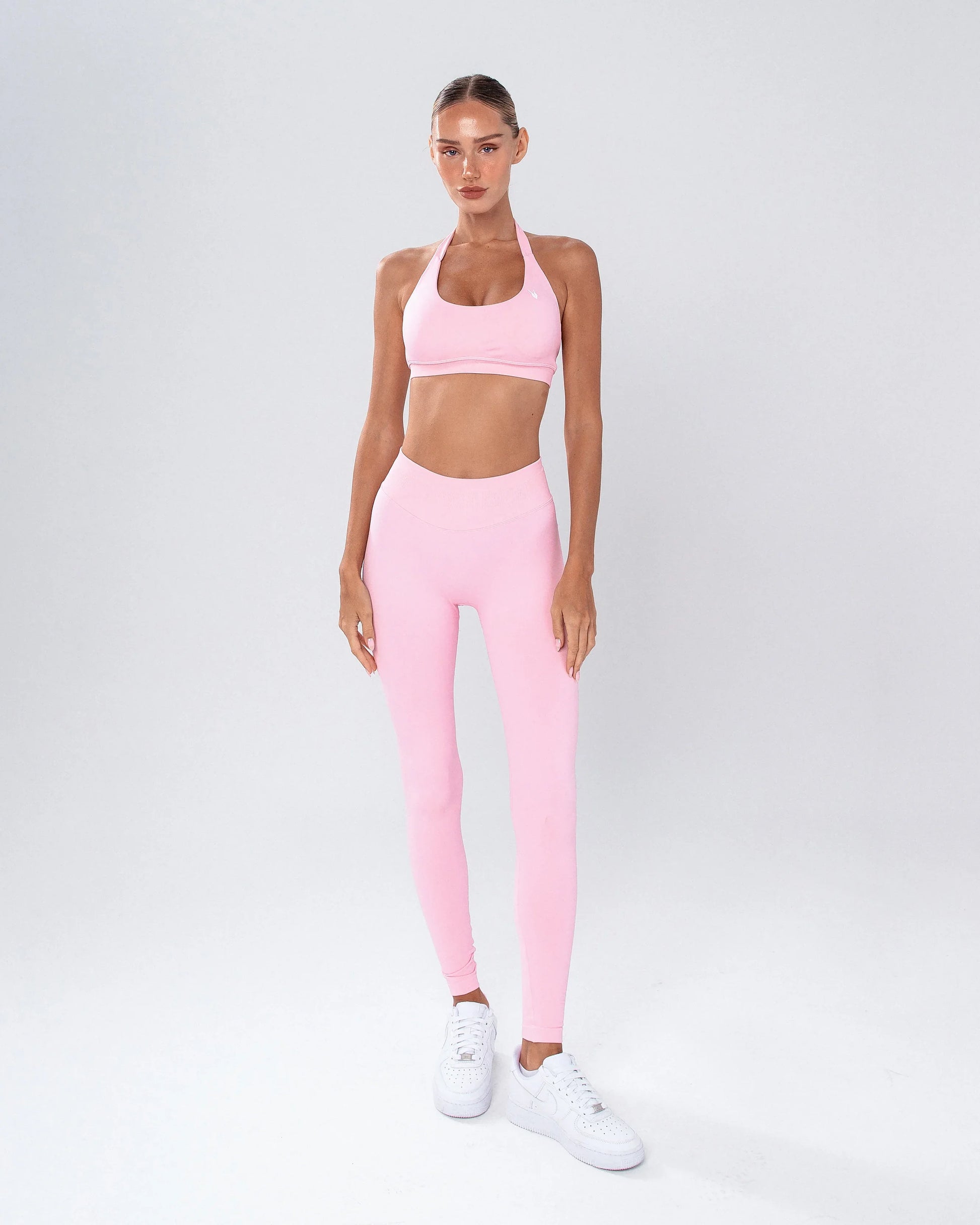 דוגמנית לובשת טייץ ורוד מחטב לנשים עם כיווץ נסתר וגזרת V – AURA PINK של Inner Dragon