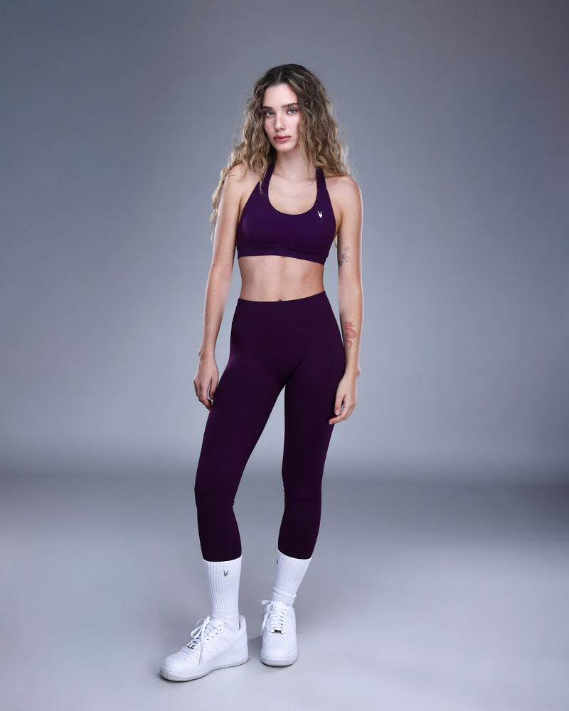 טייץ AURA VIOLET סגול של Inner Dragon – גזרה גבוהה מחטבת עם כיווץ נסתר מאחור, בד seamless איכותי ונמתח, צילום גוף מלא מקדימה עם טופ תואם בצבע סגול עמוק.