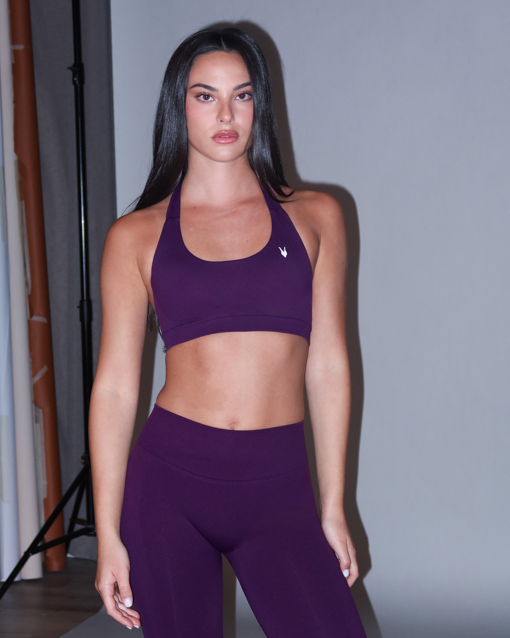 סט AURA VIOLET בצבע סגול עמוק – טופ הלטר מחמיא עם פתיחת גב אלגנטית בשילוב טייץ seamless מחטב עם כיווץ נסתר. עיצוב נשי, עמיד ונוח לאימוני כושר, פילאטיס ויוגה מבית Inner Dragon.