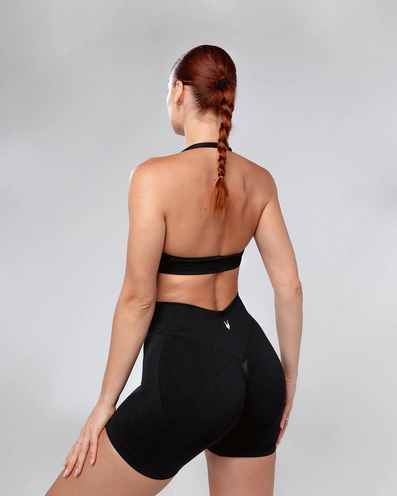 דוגמנית לובשת שורט ספורט מחטב שחור HERA BLACK מבית אינר דרגון – תצוגה אחורית, טייץ קצר מחטב לנשים, עיצוב בולט לאימון וספורט