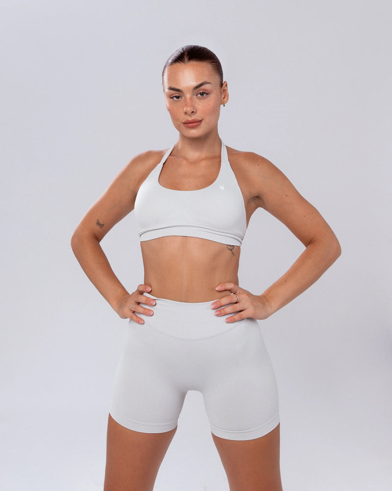 דוגמנית לובשת שורט ספורט מחטב לנשים בצבע אבן (לבן אפור), דגם HERA STONE של אינר דרגון, גזרה גבוהה, בגדי ספורט איכותיים לסטודיו, כושר ויומיום