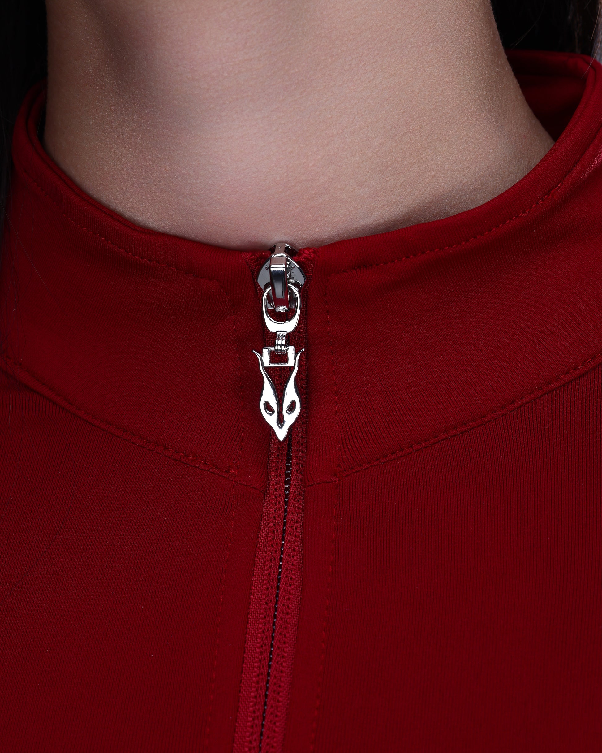 תקריב רוכסן מתכתי עם לוגו Inner Dragon בג׳קט SEAMLESS בצבע אדום יין מבית אינר דרגון