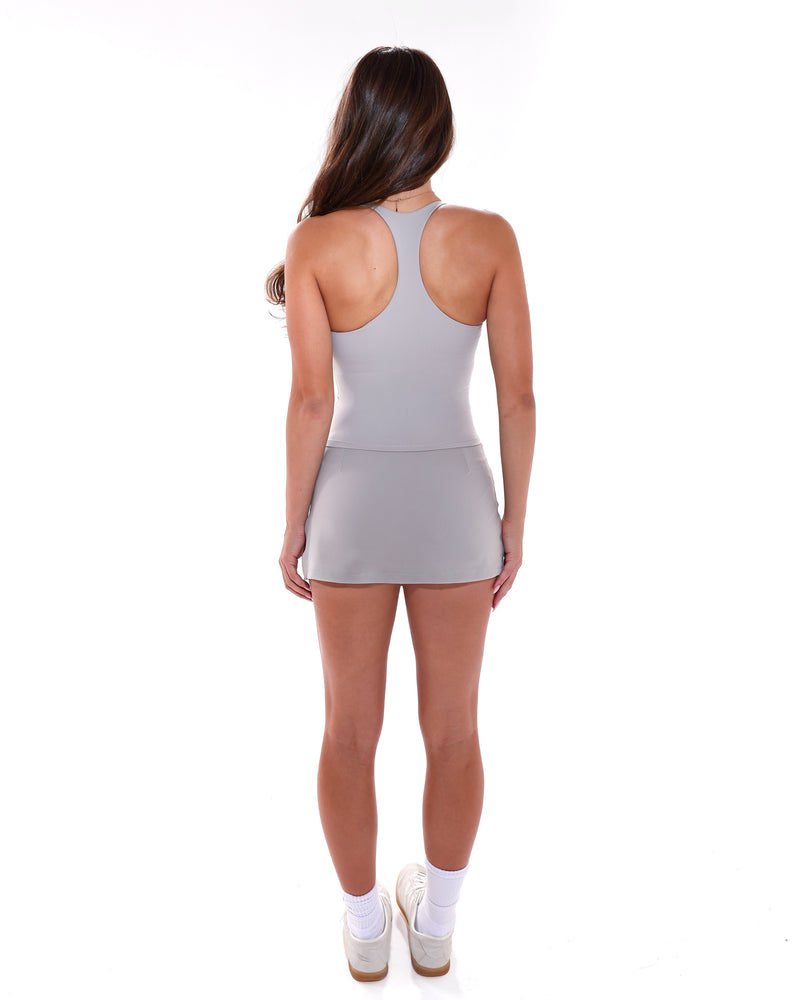 מבט מאחור: גופיית גב שחייה וחצאית מכנס MUSE בגוון MIST, צילום גוף מלא, Inner Dragon