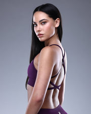 טופ ספורט NOVA VIOLET סגול של Inner Dragon – תצוגת צד של טופ ספורט אלגנטי בגזרת גב מוצלב (X-Back) בצבע סגול עמוק, עשוי בד seamless נוח ואלסטי. מעניק תמיכה מחטבת ונראות יוקרתית לאימוני כושר, פילאטיס ויוגה.