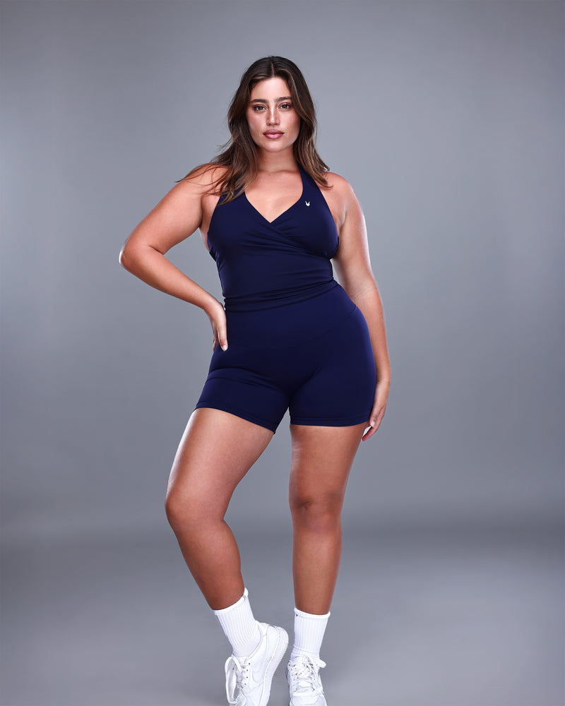 דוגמנית פלאס לובשת סט ספורט בצבע נייבי הכולל טופ מעטפת ושורט מחטב VENUS NAVY בגזרת מותן גבוהה מבית Inner Dragon – מראה נשי עוצמתי ואלגנטי