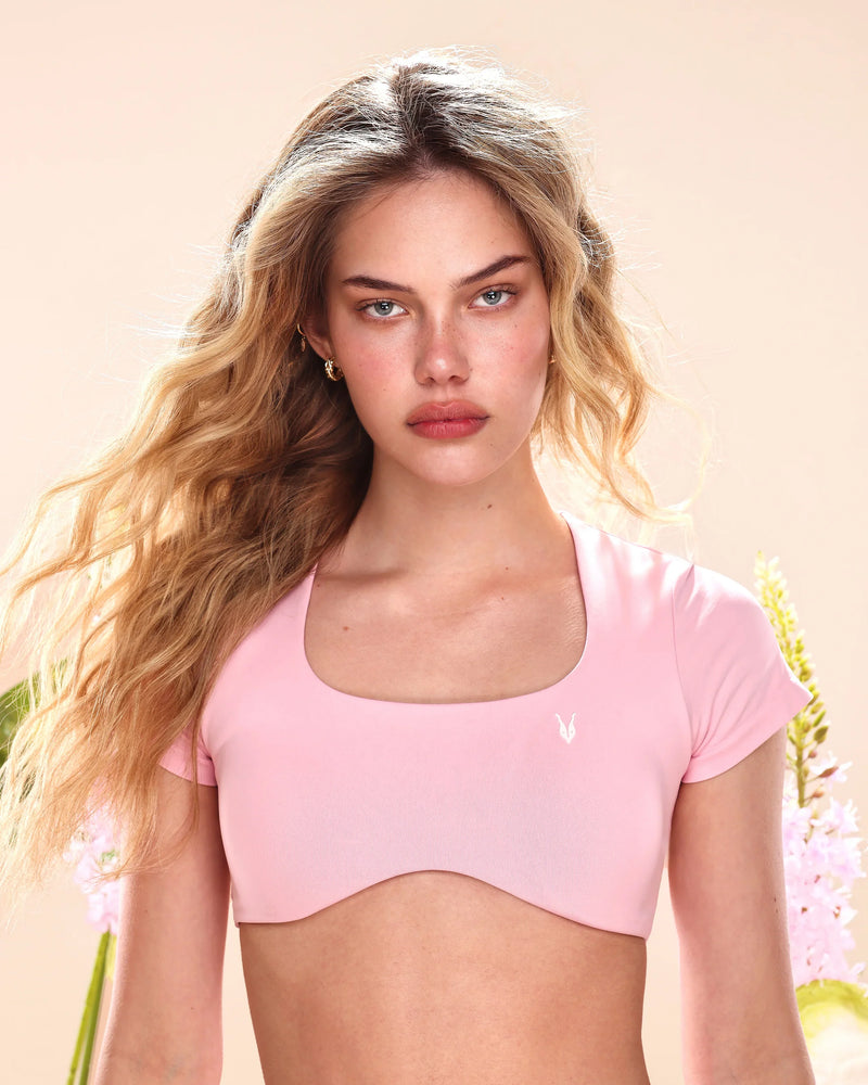 טופ ספורט ורוד עם שרוולים לנשים, דגם VENUS PINK של Inner Dragon – מחטב, אלסטי, מושלם לאימון וליום-יום. מופיע על דוגמנית.